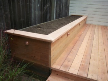 Beautiful red wood decking / flower bed with accent lighting to set it off